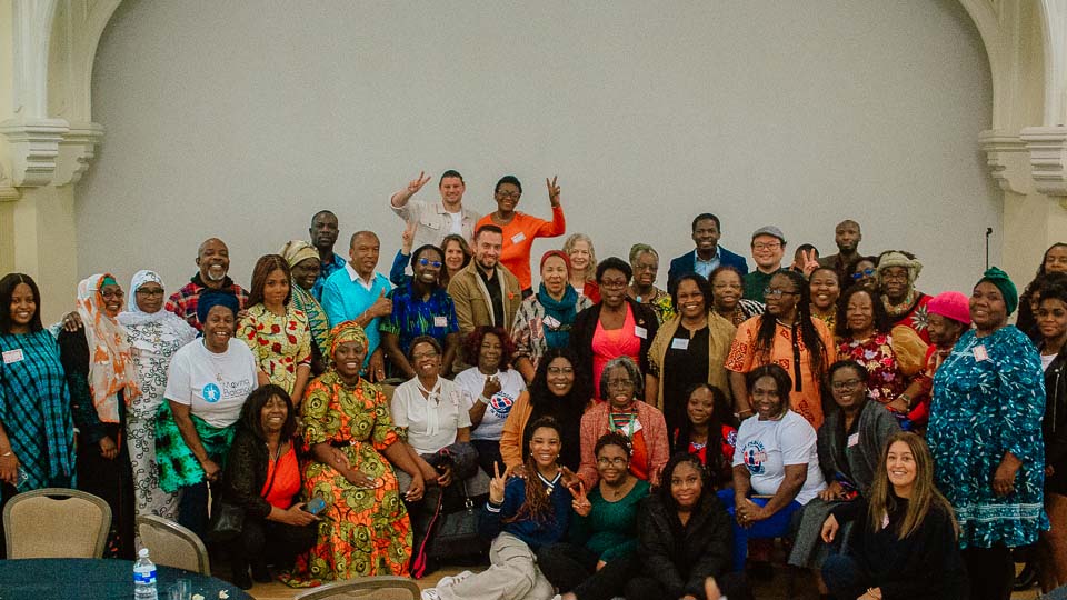 A group of attendees at the Cultural Perspectives on Aging event gather together for a group photo